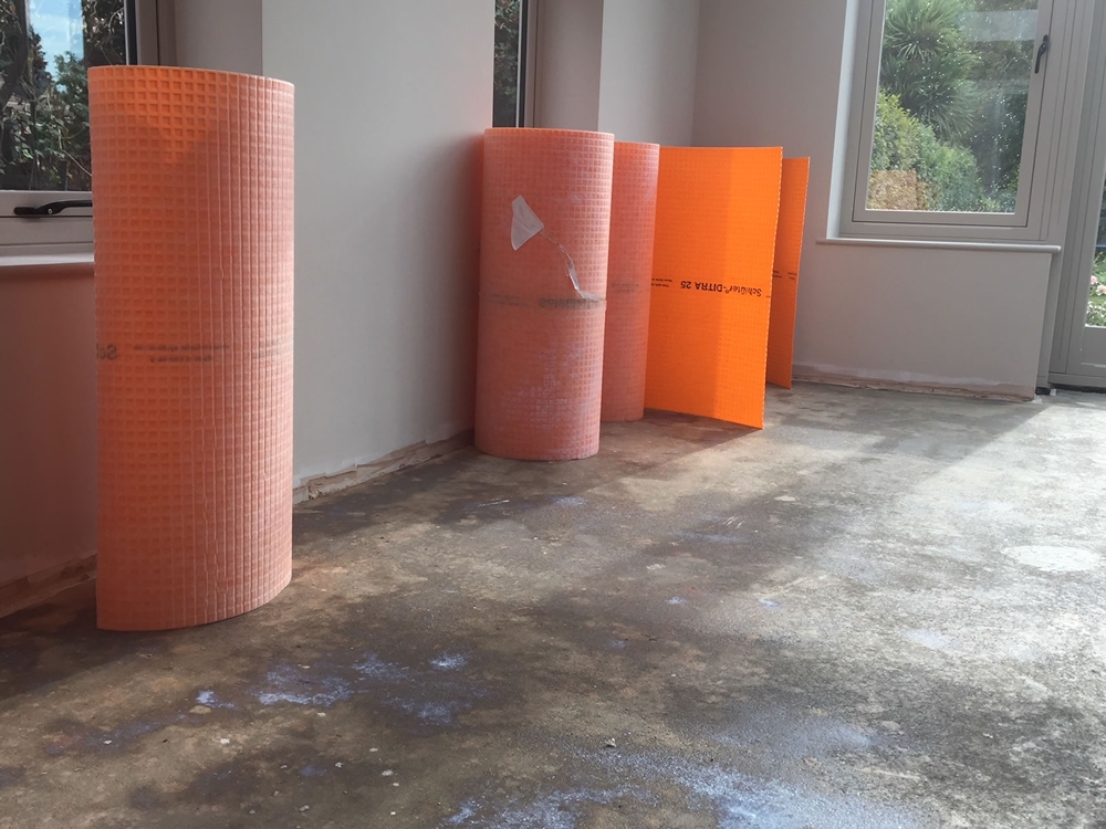 ORANGERY PROJECT STORY.  Evidence of floor sealing and show of rolls of sub tile ready to be installed on orangery floor